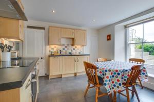 a kitchen with a table with chairs and a tablecloth on it at 2 Bed in Mousehole oc-mizpah in Mousehole +8 photos