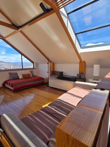 a room with skylight ceilings and a bed and a couch at Villa Florita in La Paz