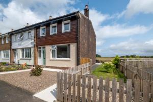 a house with a wooden fence in front of it at 3 Bed in Lucker oc-nb1938 in Lucker
