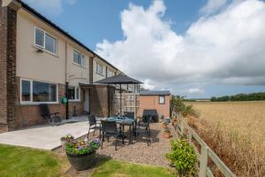 a house with a patio with a table and chairs at 3 Bed in Lucker oc-nb1938 in Lucker +12 photos