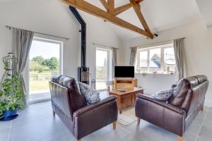 a living room with two leather chairs and a tv at 3 Bed in Chatton oc-nb1987 in Chatton