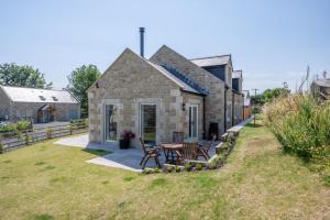 a stone house with a table and chairs in the yard at 3 Bed in Chatton oc-nb1987 in Chatton