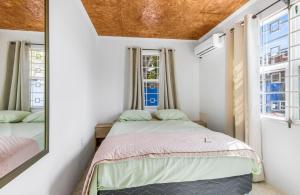 a small bedroom with a bed and a mirror at The blue wave in Willemstad