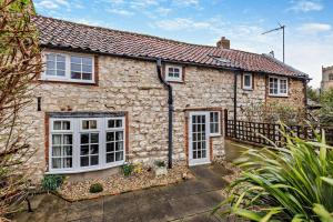 an old stone house with white doors and windows at 2 Bed in Brancaster oc-b28394 in Brancaster +11 photos