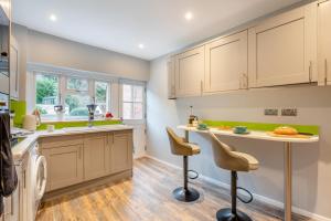 a kitchen with white cabinets and a table and chairs at 1 Bed in Lewes oc-n29713 in Lewes +10 photos