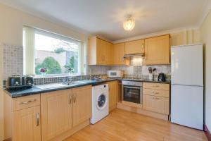 a kitchen with wooden cabinets and a white refrigerator at 1 Bed in Robeston Wathen oc-pw9200 in Robeston Wathen