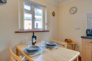 a kitchen with a table with plates and a bottle of wine at 1 Bed in Robeston Wathen oc-pw9200 in Robeston Wathen