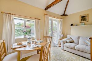 a living room with a table and a couch at 1 Bed in Barton Turf oc-s29126 in Neatishead