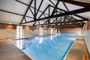 a large indoor swimming pool with blue water at 1 Bed in Barton Turf oc-s29126 in Neatishead