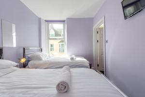 two beds in a white room with a window at 2 Bed in Tenby oc-w28987 in Tenby