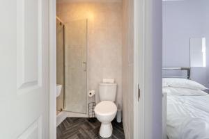 a bathroom with a toilet and a shower and a bed at 2 Bed in Tenby oc-w28987 in Tenby