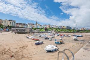a group of boats sitting on the sand on a beach at 2 Bed in Tenby oc-w28987 in Tenby