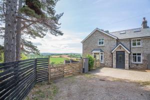 a stone house with a fence and a tree at 3 Bed in Llysfaen oc-t32226 in Llysfaen