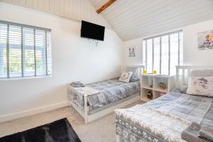a bedroom with two beds and a flat screen tv at 3 Bed in Llysfaen oc-t32226 in Llysfaen