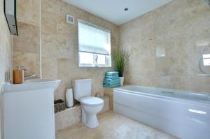 a bathroom with a tub and a toilet and a sink at 5 Bed in Amroth oc-pw9068 in Amroth +17 photos