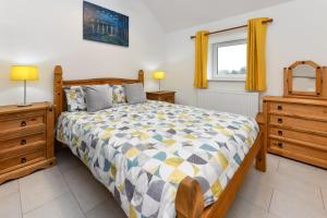 a bedroom with a bed and two dressers and a window at 2 Bed in Bwlchtocyn oc-thetac in Abersoch