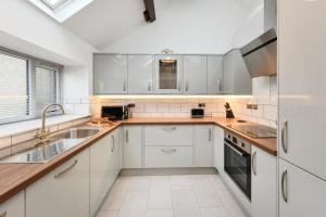 a kitchen with white cabinets and a sink at 2 Bed in Bwlchtocyn oc-thetac in Abersoch +15 photos