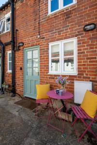 two chairs and a table in front of a brick building at 2 Bed in Aldeburgh oc-3al in Aldeburgh +4 photos