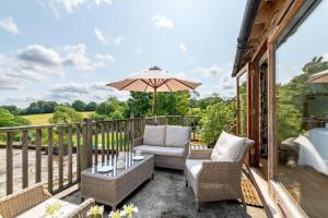 an outdoor patio with chairs and an umbrella at 3 Bed in Wadhurst oc-tw665 in Wadhurst