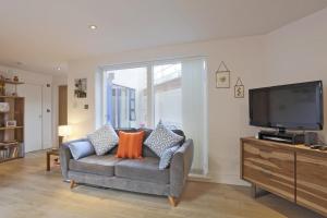 a living room with a couch and a flat screen tv at 2 Bed in Southwold oc-wtp in Southwold
