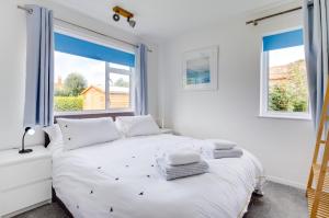 ein Schlafzimmer mit einem weißen Bett und zwei Fenstern in der Unterkunft 2 Bed in Docking oc-2212 in Docking