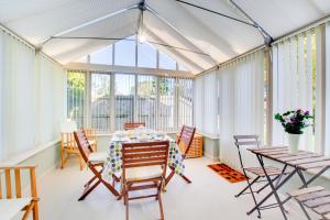 a conservatory with a table and chairs and windows at 2 Bed in Briston oc-1551 in Briston +7 photos