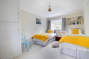 two beds in a white room with yellow sheets at 2 Bed in Ufford oc-sfmcu in Ufford