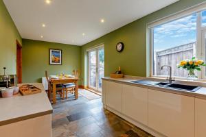 a kitchen with green walls and a sink and a table at 3 Bed in North Shields oc-b29939 in Tynemouth