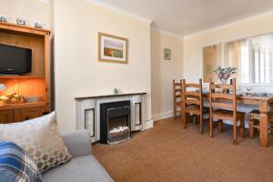 a living room with a table and a fireplace at 4 Bed in Bwlchtocyn oc-uchaf in Abersoch