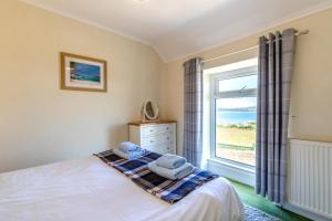 a bedroom with a bed and a window at 4 Bed in Bwlchtocyn oc-uchaf in Abersoch