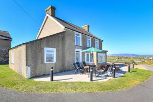 a house with a patio with a table and chairs at 4 Bed in Bwlchtocyn oc-uchaf in Abersoch