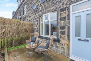 a patio with rattan chairs and tables and a building at 3 Bed in Ilkley oc-i30726 in Ilkley