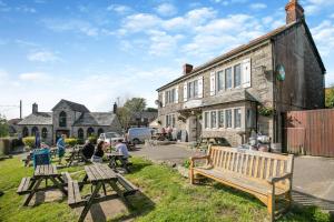 a group of people sitting on benches in front of a building at 5 Bed in Bodmin oc-l29658 in Blisland