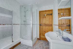 ein weißes Badezimmer mit Dusche und Waschbecken in der Unterkunft 3 Bed in Fakenham oc-1315 in Thursford + 17 Fotos