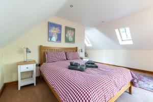 ein Schlafzimmer mit einem Bett mit einer rot-weiß karierten Tagesdecke in der Unterkunft 3 Bed in Fakenham oc-1315 in Thursford