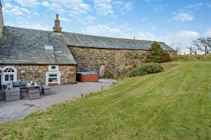 a stone building with a grassy field next to it at 4 Bed in Kinniside oc-c28854 in Frizington