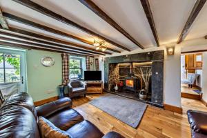 a living room with a leather couch and a fireplace at 3 Bed in Fucheswen oc-m29608 in Blaenau-Ffestiniog