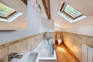 a bathroom with a tub and a sink and skylights at 3 Bed in Fucheswen oc-m29608 in Blaenau-Ffestiniog +32 photos