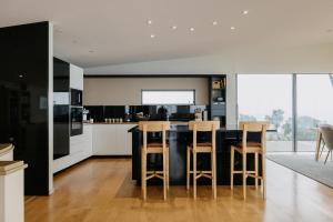 a kitchen with a table and some chairs in it at Peak View Retreat in Nelson +21 photos