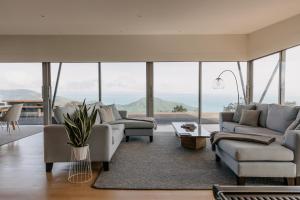 a living room with couches and chairs and a large window at Peak View Retreat in Nelson