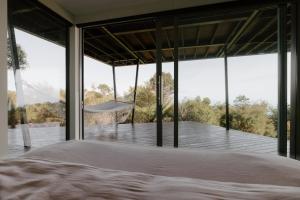 a bedroom with a bed and large windows at Peak View Retreat in Nelson