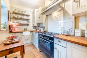 a kitchen with white cabinets and a blue stove top oven at 4 Bed in Alnmouth oc-a30221 in Alnmouth