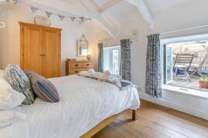 a bedroom with a bed and a window with a chair at 1 Bed in Porthleven oc-smuggl in Porthleven
