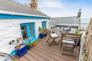 a patio with a table and chairs on a deck at 1 Bed in Porthleven oc-smuggl in Porthleven