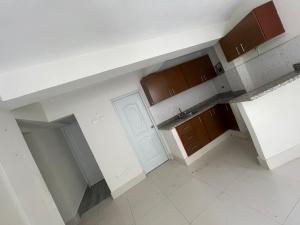 an empty kitchen with white walls and brown cabinets at Bohio rd in Santo Domingo