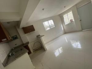 an empty kitchen with two windows and a white floor at Bohio rd in Santo Domingo