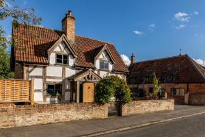 a white house with a brick retaining wall at 5 Bed in Frampton On Severn oc-d29489 in Frampton on Severn