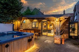 a hot tub on a patio with a house at 5 Bed in Frampton On Severn oc-d29489 in Frampton on Severn