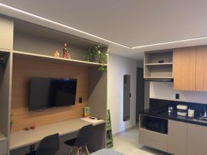a room with a desk and a tv on a wall at Lindo Studio com rooftop e piscina in Cabedelo
