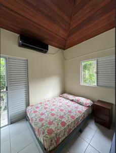 a bedroom with a bed in a room with windows at Casa em Mongaguá in Mongaguá
